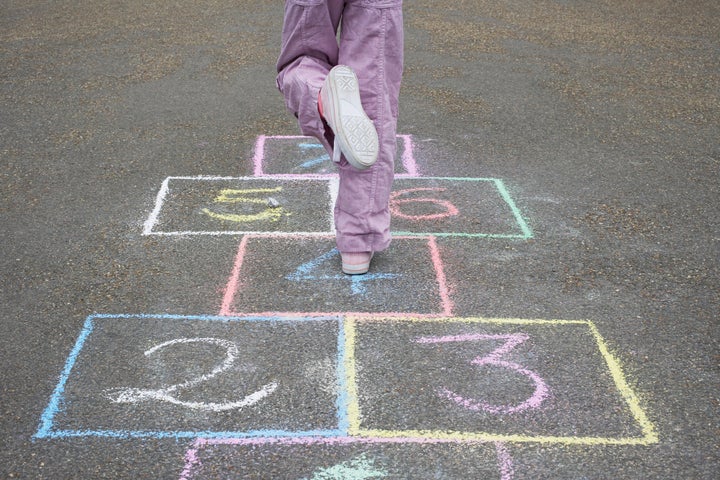 Una niña jugando a la rayuela.