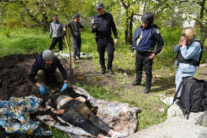 Police and volunteers exhume the bodies of civilians killed by Russian shelling in the village of Stepaky, close to Kharkiv, Ukraine, on May 11, 2022.
