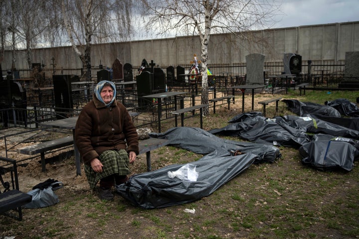 Nadiya Trubchaninova, 70, sits next to a plastic bag that contains the body of her son Vadym Trubchaninov, 48, who was killed by Russian soldiers in Bucha on March 30, in the outskirts of Kyiv, Ukraine, on April 12, 2022.