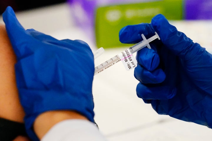 A health worker administers a dose of a Moderna COVID-19 vaccine during a vaccination clinic in Norristown, Pa., on Dec. 7, 2021. 