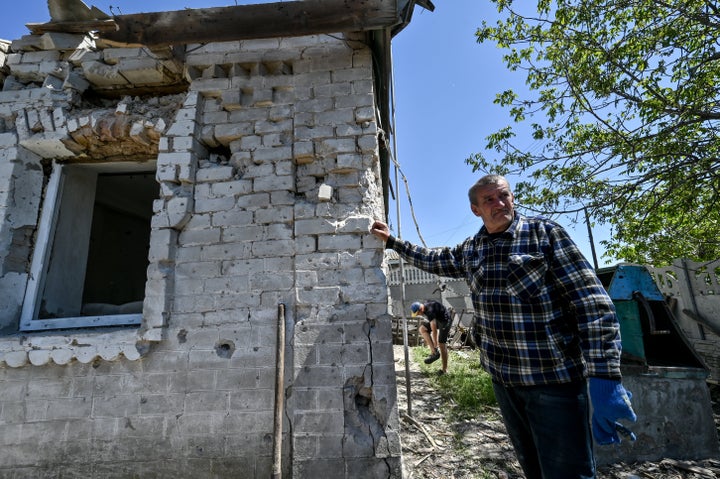 Hombre ucraniano cerca de su casa tras sufrir un ataque ruso.