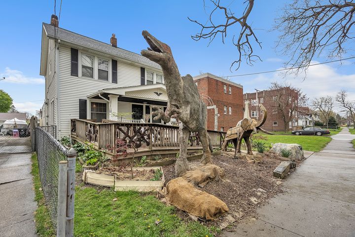 Animal statues, including a 12-foot dinosaur sculpture, tower over the front lawn of a Cleveland home.