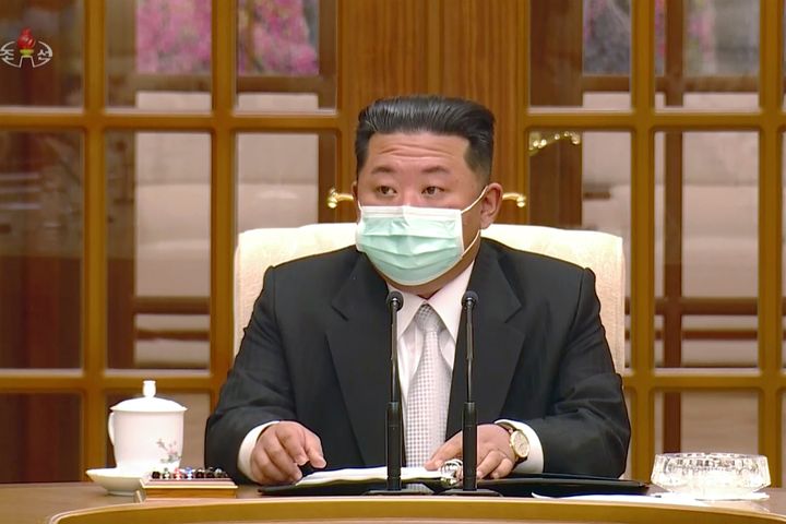 North Korean leader Kim Jong Un wears a face mask on state television during a meeting Thursday in Pyongyang acknowledging the country's first case of COVID-19.
