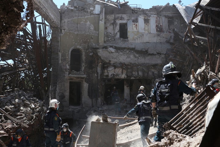 Ukraine Places Russian Soldier Accused Of Battle Crime On Trial 12 Donetsk People Republic Emergency Situations Ministry employees clear rubble at the side of the damaged Mariupol theater building during heavy fighting in Mariupol, in territory under the government of the Donetsk People's Republic, eastern Ukraine, on May 12, 2022.