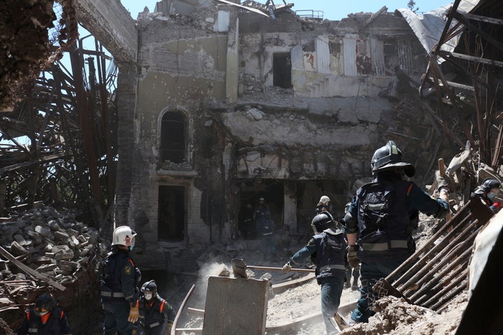 Donetsk People Republic Emergency Situations Ministry employees clear rubble at the side of the damaged Mariupol theater building during heavy fighting in Mariupol, in territory under the government of the Donetsk People's Republic, eastern Ukraine, on May 12, 2022. 