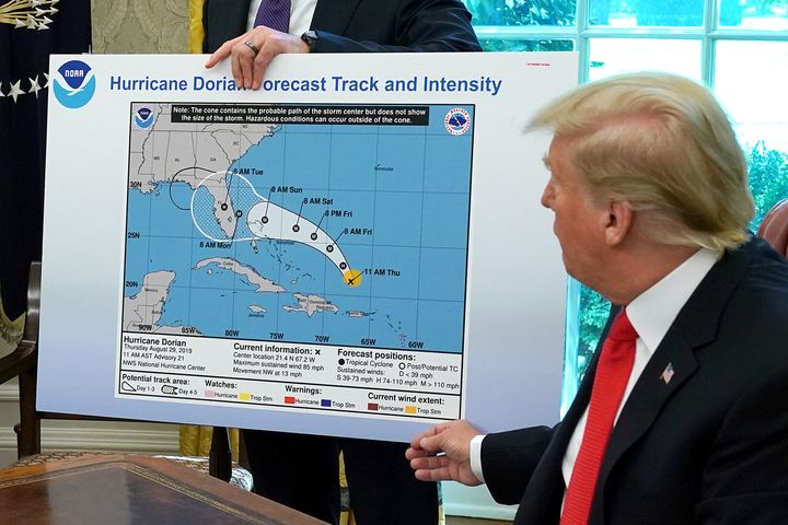 President Donald Trump references a map held by acting Homeland Security Secretary Kevin McAleenan, while talking to reporters following a briefing from officials about Hurricane Dorian in the Oval Office, on Sep. 4, 2019. The map appears to have been altered by a black marker to extend the hurricane's range to include Alabama.
