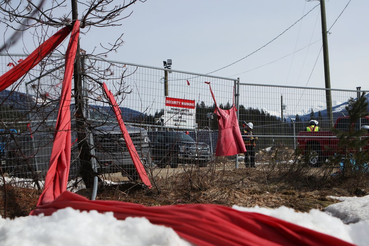 Members of the Tiny House Warriors display red dresses and cloth to honor missing and murdered Indigenous women and girls along the perimeter of a camp that houses 550 Trans Mountain Pipeline workers in Blue River, B.C.