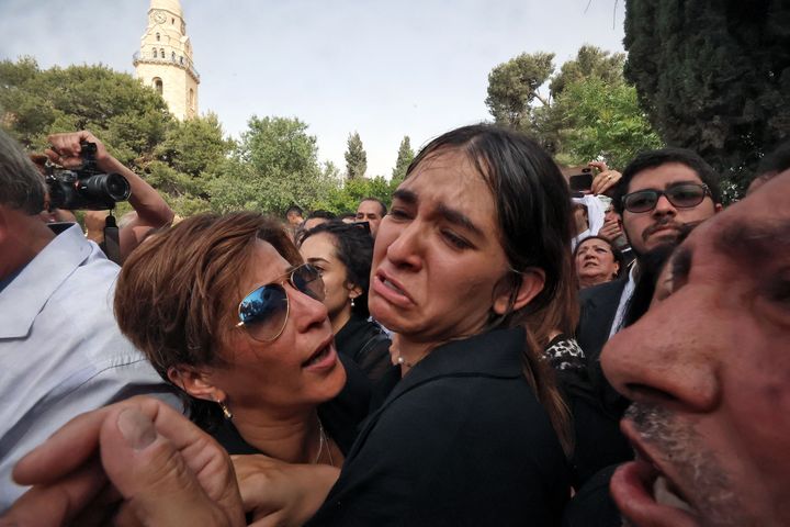 Mourners react during the burial of slain veteran Al-Jazeera journalist Shireen Abu Akleh at the Mount Zion Cemetery outside Jerusalem's Old City on May 13, two days after she was killed while covering an Israeli army raid in the West Bank.