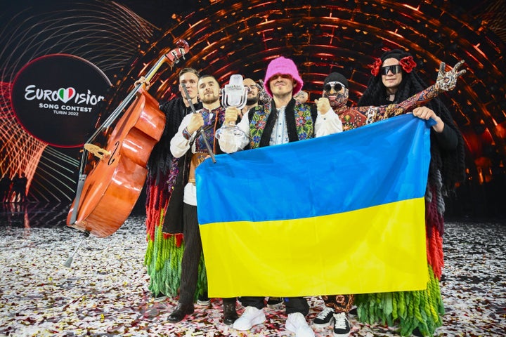 Members of the band "Kalush Orchestra" pose onstage with the winner's trophy and Ukraine's flags after winning on behalf of Ukraine the Eurovision Song contest 2022 on May 14, 2022 at the Pala Alpitour venue in Turin. (Photo by Marco BERTORELLO / AFP) (Photo by MARCO BERTORELLO/AFP via Getty Images)