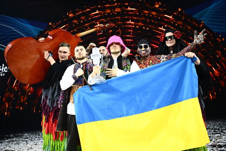 Members of the band Kalush Orchestra pose onstage with the winner's trophy as Ukraine wins Eurovision