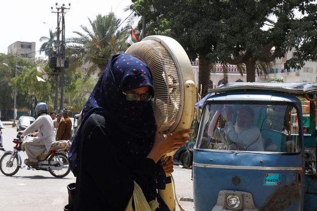 La température a dépassé les 50°C à l'ombre au Pakistan, un record mondial pour 2022 (Photo d'une femme transportant un ventilateur dans les rues de Karachi au Pakistan le 11 mai 2022. Par REUTERS/Akhtar Soomro)