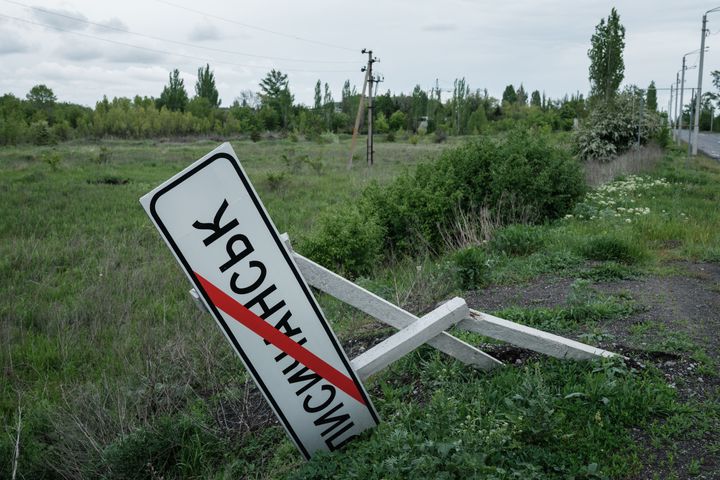A road sign indicating the name of the city of Lysychansk, is broken on the side of a road on the outskirts of Lysychansk, eastern Ukraine.