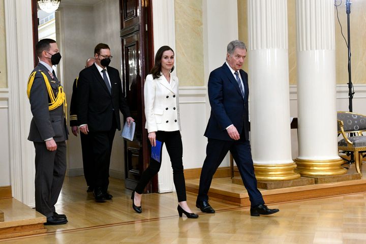 Finland's President Sauli Niinisto, right, and Prime Minister Sanna Marin arrive for the press conference on Finland's security policy decisions at the Presidential Palace in Helsinki, Finland, Sunday May 15, 2022. (Heikki Saukkomaa/Lehtiuva via AP)