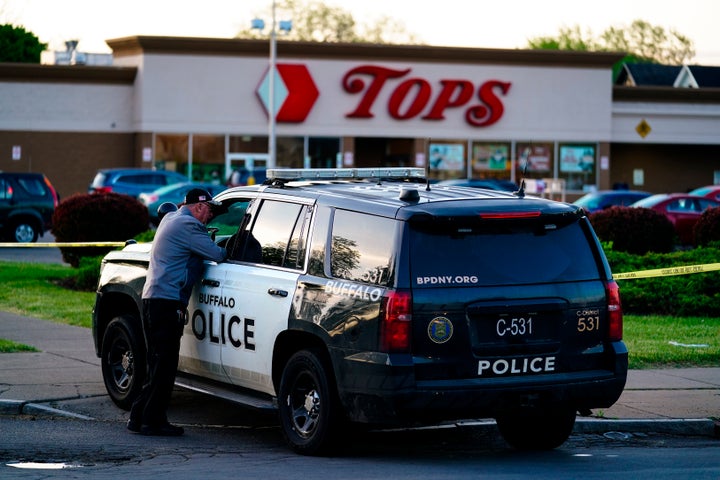 Police are seen parked outside the scene of Saturday's shooting that left 10 people dead.