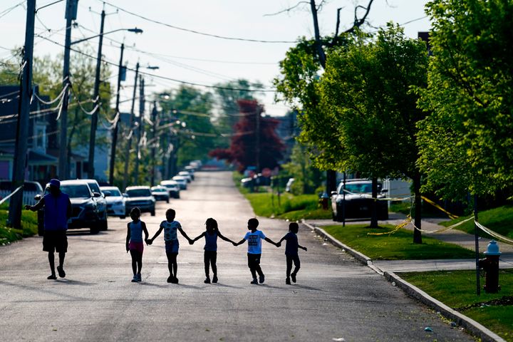 Children hold hands near the scene of Saturday's shooting in Buffalo.