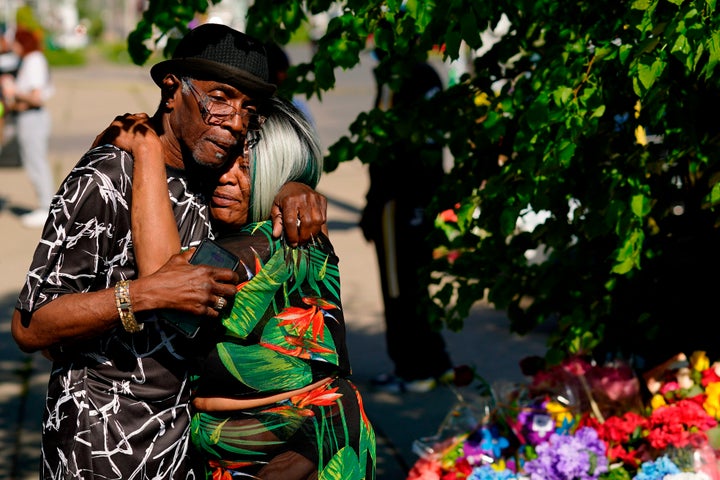 People embrace outside the scene of a shooting at a supermarket a day earlier, in Buffalo on Sunday.