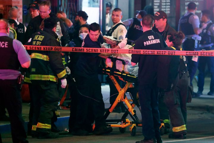 First responders move a shooting victim to an ambulance on Adams Street near State Street in downtown Chicago on May 14, 2022. The downtown area saw gun violence and disturbances after a teenage boy was shot and fatally wounded near “The Bean” sculpture in downtown Chicago's Millennium Park.