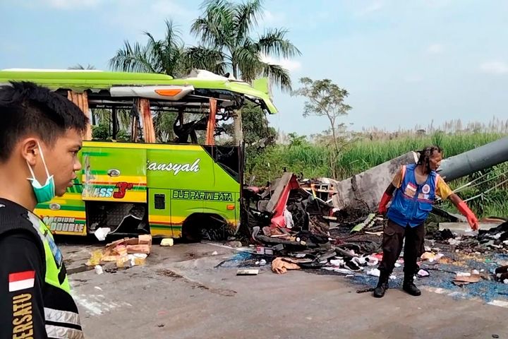 Διασώστες στα συντρίμμια του τουριστικού λεωφορείου που έπεσε σε πινακίδα σε αυτοκινητόδρομο στο Μοτζοκέρτο, στην Ανατολική Ιάβα.