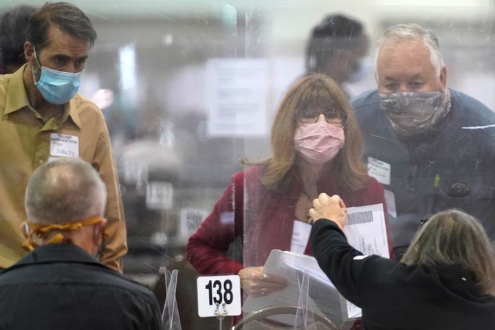 Recount observers check ballots on Nov. 20, 2020, during a Milwaukee hand-recount of presidential votes. A narrowly divided Wisconsin Supreme Court later rejected Donald Trump's lawsuit attempting to overturn his loss to Democrat Joe Biden about an hour before the Electoral College was to meet to cast the state's 10 votes for Biden.