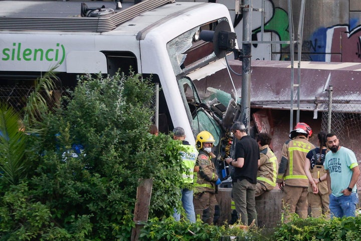 Miembros de los servicios de emergencia y agentes de los Mossos d'Esquadra asisten al lugar en el que se produjo un choque entre un tren de mercancías y uno de pasajeros entre las estaciones de Sant Boi de Llobregat y Molí Nou de la línea Llobregat-Anoia de Ferrocarrils de la Generalitat de Catalunya (FGC).