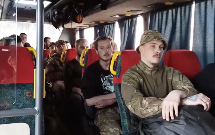 In this photo taken from video released by the Russian Defense Ministry Press Service on May 17, 2022, Ukrainian servicemen sit in a bus as they are being evacuated from the besieged Azovstal steel plant in Mariupol, Ukraine.