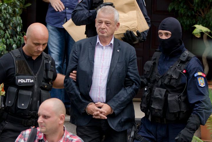 Αστυνομικοί συνοδεύουν τον δήμαρχο του Βουκουρεστίου Σορίν Οπρέσκου με χειροπέδες από το σπίτι του στο Τσιολπάνι της Ρουμανίας, Κυριακή, Σεπτ. 6, 2015.