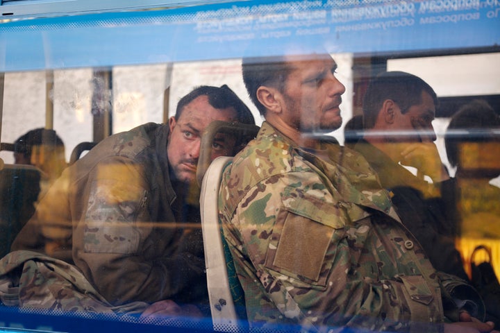 Ukrainian servicemen sit in a bus after they were evacuated from the besieged Mariupol's Azovstal steel plant, near a remand prison in Olyonivka, in territory under the government of the Donetsk People's Republic, eastern Ukraine, on May 17, 2022.