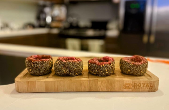 The raw patties, rolled in the breadcrumb mixture.