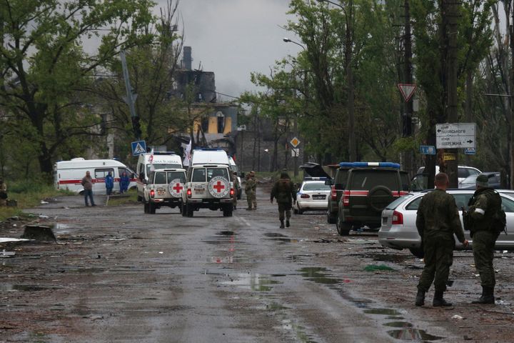 Des membres du personnel de la Croix-Rouge se rendent dans leurs véhicules à l'usine sidérurgique d'Azovstal pour observer l'évacuation des militaires ukrainiens à Marioupol, dans le territoire sous le gouvernement de la République populaire de Donetsk, dans l'est de l'Ukraine, le 18 mai 2022.