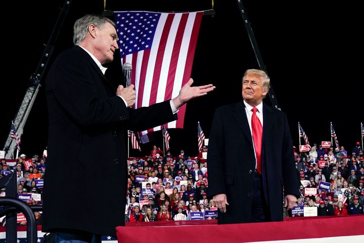 Sen. David Perdue (R-Ga.) speaks as President Donald Trump looks on at a campaign rally at Valdosta Regional Airport in December 2020. Perdue is building his 2022 gubernatorial campaign around Trump and veering to the right as he tries to unseat Republican Gov. Brian Kemp in the primary.