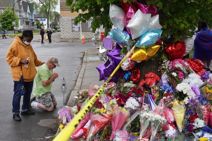 People visit a makeshift memorial set up outside the Tops supermarket on May 18, 2022 in Buffalo, New York. A gunman opened fire at the store on Saturday, killing 10 people and wounding three others. Police say it's being investigated as a racially motivated hate crime.