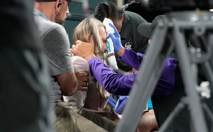 Colorado Rockies television reporter Kelsey Wingert is attended to after being hit by a foul ball off the bat of San Francisco Giants' Austin Slater in the ninth inning of a baseball game Monday, May 16, 2022, in Denver. (AP Photo/David Zalubowski)