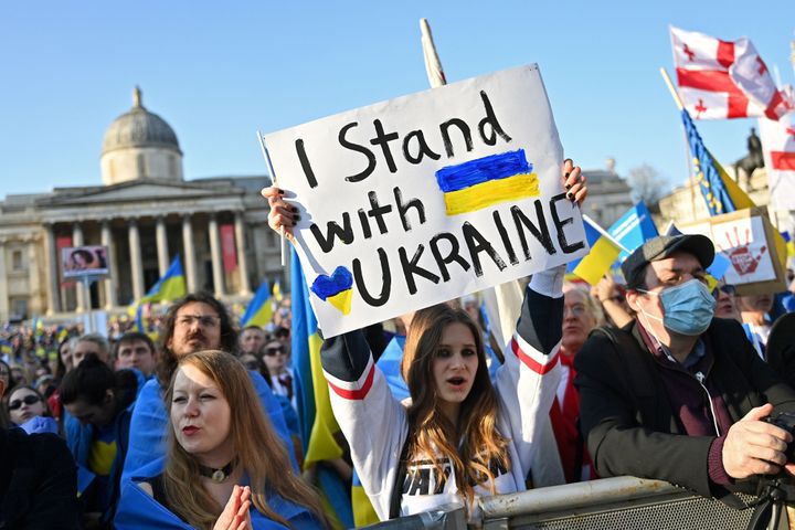 People hold placards and Ukrainian national flags in Trafalgar Square, during a 'London stands with Ukraine' protest march and vigil.