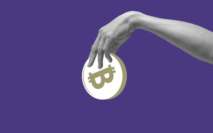 Mano sosteniendo una bitcoin.