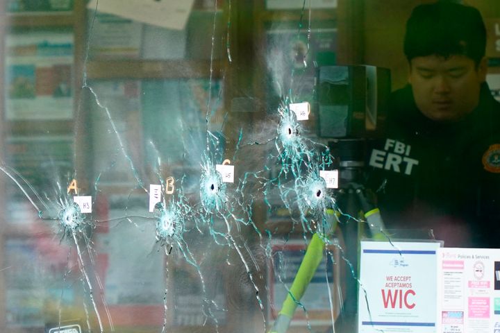 Un investigador policial revisa el supermercado atacado en Búfalo, con los cristales tiroteados. 