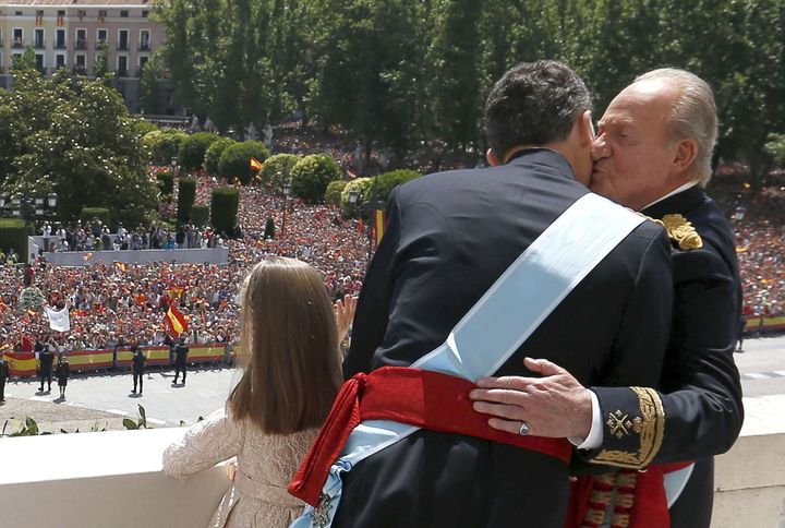 Juan Carlos I besa a su hijo recién coronado Felipe VI en el balcón del Palacio Real de Madrid.