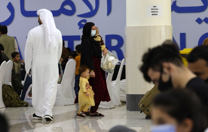 Emirati men walk among refugees who fled Afghanistan after the takeover of their country by the Taliban, as they gather at the Emirates Humanitarian City in Abu Dhabi on Aug. 28.