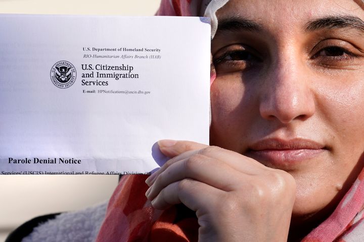 Haseena Niazi, a 24-year-old from Afghanistan, holds a parole denial notice she received from the Department of Homeland Security, while posing outside her home on Dec. 17, 2021.