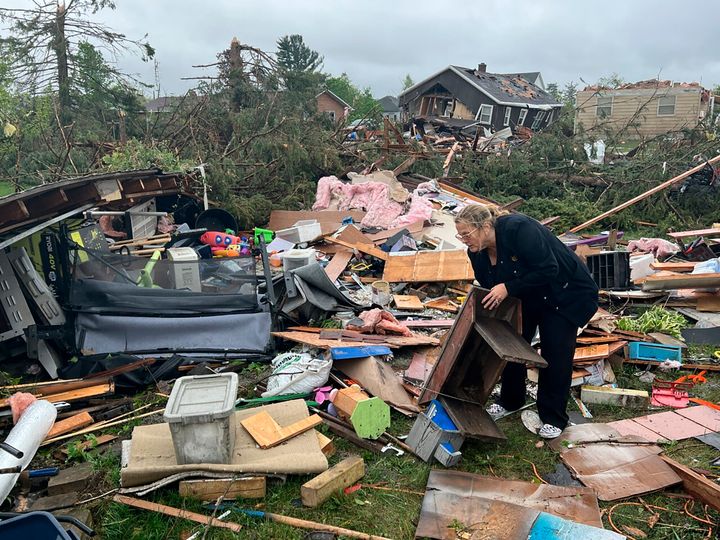 Theresa Haske goes through her damaged belongings in the debris left behind by a tornado that killed one and wiped through a city in Northern Michigan.