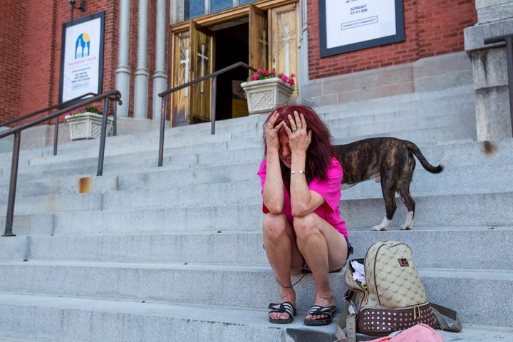 Katherine Mielnicki sits on the steps and cries outside of Roberta Drury's funeral service, Saturday, May 21, 2022, in Syracuse, New York. "I can't go in there, I just can't do it," said Mielnicki, who lived with Drury for a time.