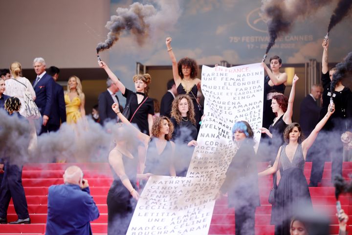 カンヌ映画祭のレッドカーペットで、DVの結果死亡した女性129人の名前が書かれた横断幕を掲げたフェミニスト団体「Les Colleuses」（2022年5月22日撮影）