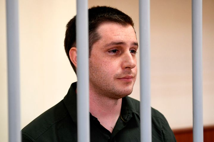 Former U.S. Marine Trevor Reed, charged with attacking police, stands inside a defendants' cage during a court hearing in Moscow on March 11, 2020.