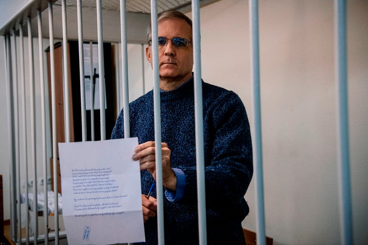 Paul Whelan, a former U.S. Marine accused of espionage in Russia, holds a message as he stands inside a defendants' cage before a hearing to decide to extend his detention at the Lefortovo Court in Moscow, on Oct. 24, 2019.