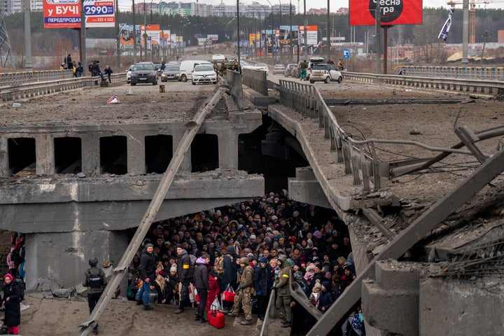 Crowds under a destroyed bridge as Ukrainians attempt to escape across the Irphine River outside Kyiv, Ukraine on March 5, 2022.