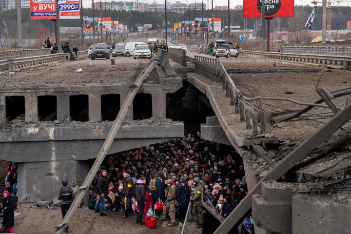 Ukrainians crowd under a destroyed bridge as they try to flee across the Irpin River in the outskirts of Kyiv, Ukraine, on March 5, 2022.