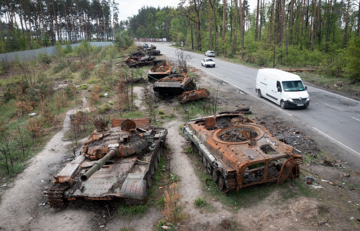 The vehicles passed through the destroyed Russian tanks fighting with the Ukrainians in the Ukrainian village of Dmitryvka near Kiev on May 23, 2022.