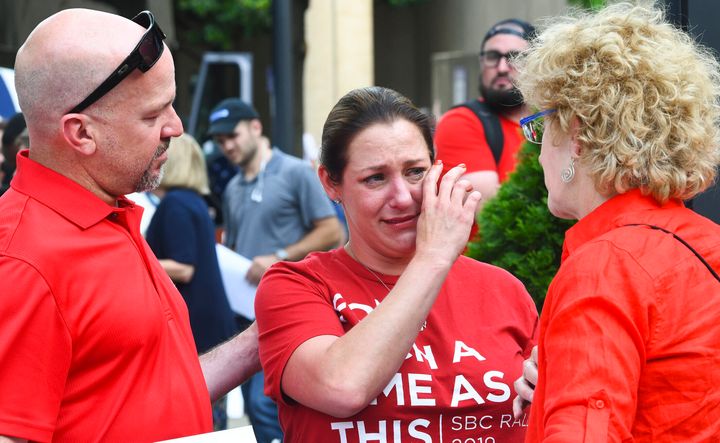 In this Tuesday, June 11, 2019 file photo, Jules Woodson, center, of Colorado Springs, Colo., is comforted by her boyfriend Ben Smith, left, and Christa Brown during a demonstration outside the Southern Baptist Convention's annual meeting in Birmingham, Ala. First-time attendee Woodson spoke through tears as she described being abused sexually by a Southern Baptist minister. A blistering report on the Southern Baptist Convention’s mishandling of sex abuse allegations, released on Sunday, May 23, 2022, is raising the prospect that the denomination, for the first time, will create a publicly accessible database of pastors and other church personnel known to be abusers. (AP Photo/Julie Bennett, File)