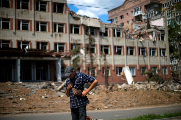 A local resident stands next to a heavily damaged building in a Russian bombing opposite his house in Bakhmut, eastern Ukraine, on May 24, 2022.