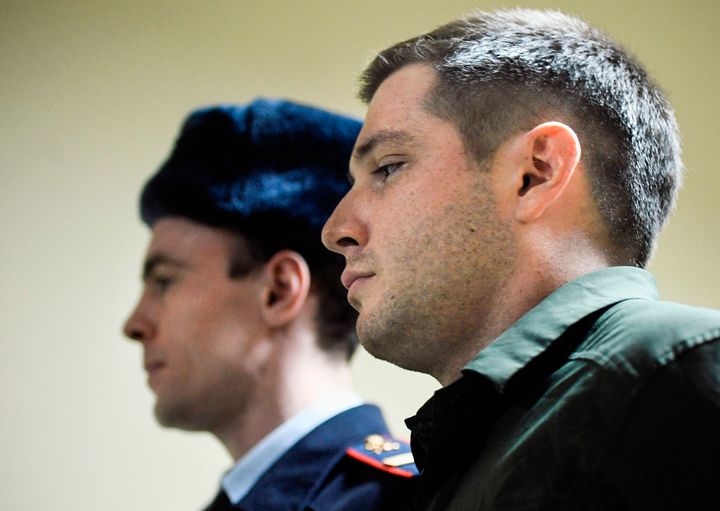 Police officers escort US ex-marine Trevor Reed, charged with attacking police, into a courtroom prior to a hearing in Moscow on March 11, 2020. 