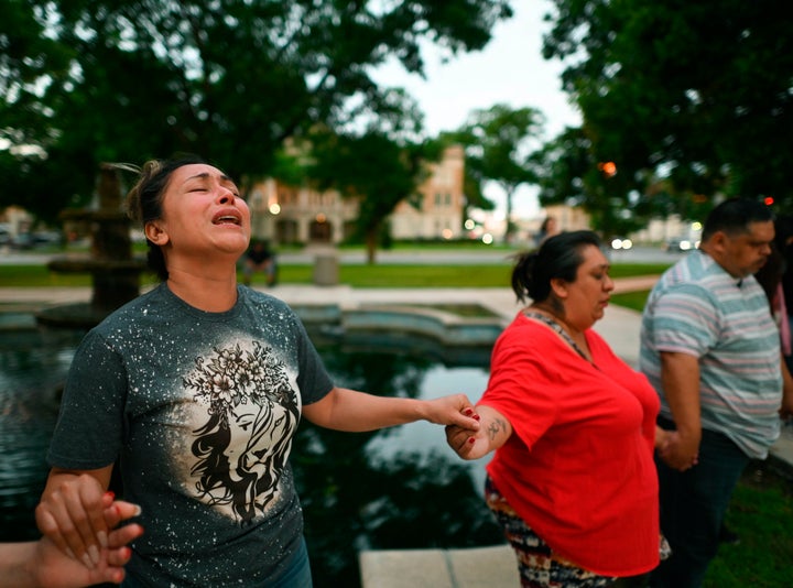 Varios familiares rezan en un vigilia frente al colegio Robb Elementary